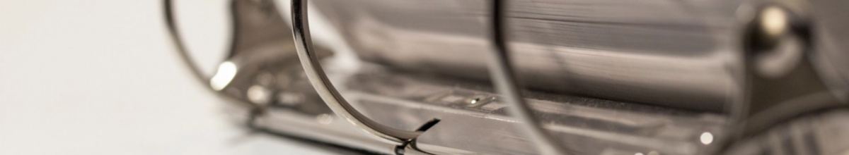 A metal ring binder mechanism holding a thick set of papers.