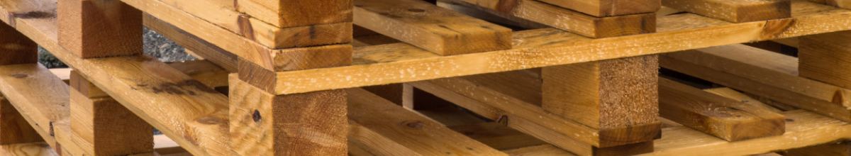 A stack of empty timber pallets seen from one end.
