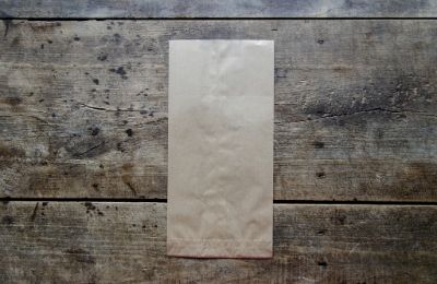A plain paper bag lying on weathered wooden boards.